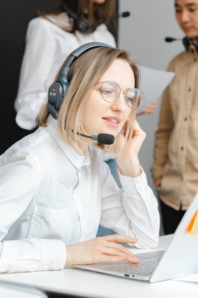 Customer support professionals working with headsets and laptops in a modern office environment.